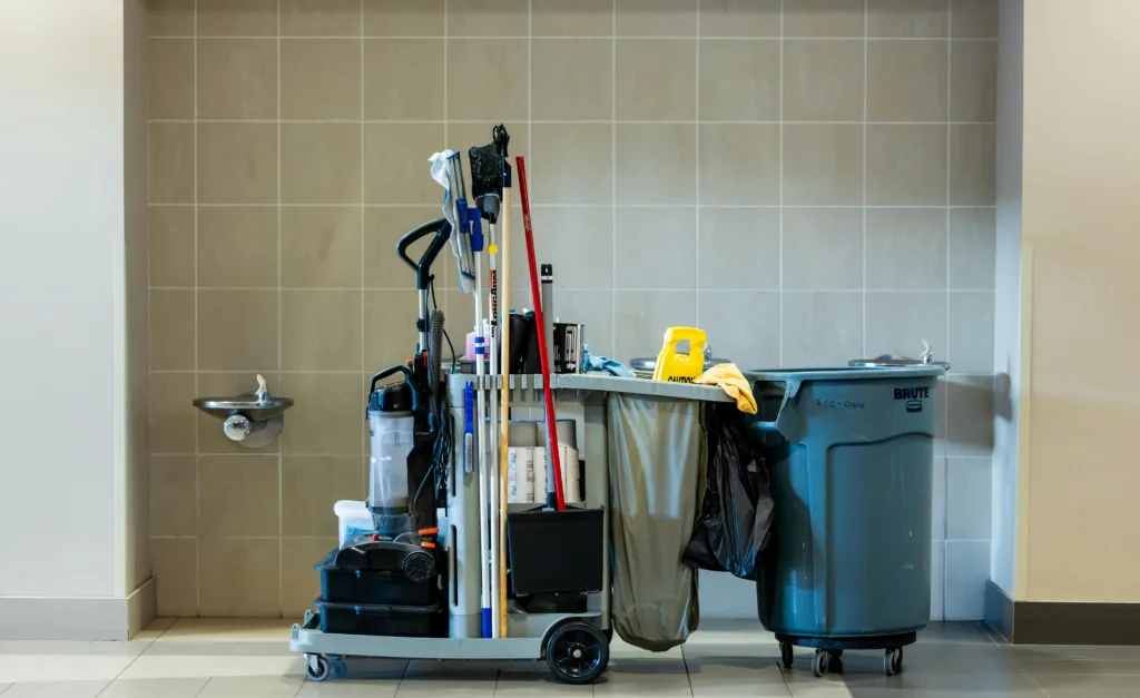 A comprehensive collection of professional cleaning tools on a cart in an indoor environment.